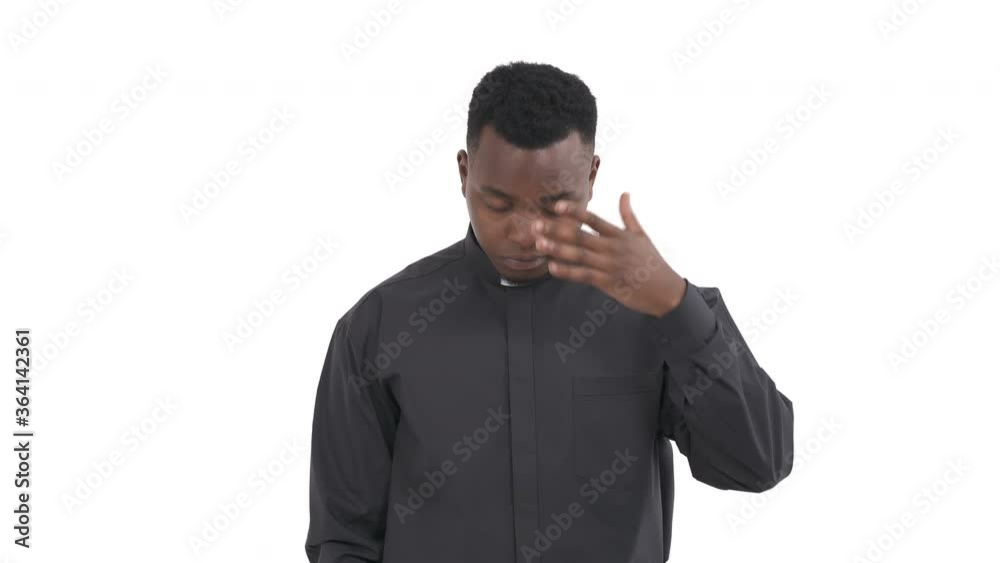 Portrait of disappointed black priest with hand on his forehead and lowered eyes expressing despair emotion isolated on white background Portrait of disappointed black priest with hand on his forehead and lowered eyes expressing despair emotion isolated on white background
