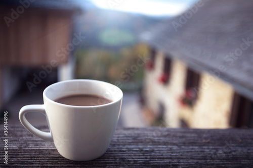cup of coffee on a background of a house in the mountains