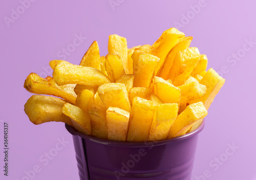 French fries close-up. Deep-fried food. French fries on purple background