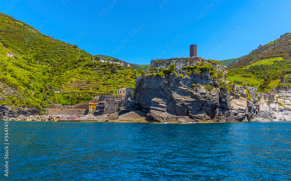 A view from the sea passing the castle hill in the Cinque Terre village of Vernazza in the summertime