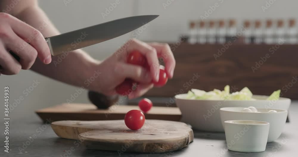 Slow motion slide shot of man put cherry tomatoes on olive wood board Slow motion slide shot of man put cherry tomatoes on olive wood board