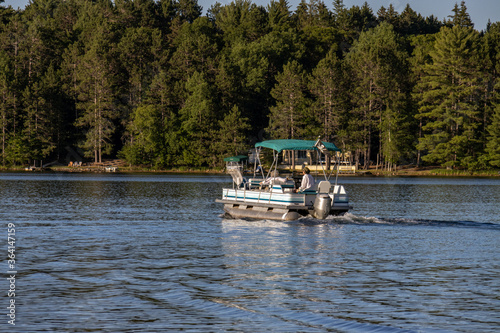 pontoon boat cruising  on lake photo