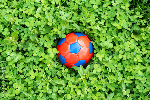 Fototapeta Child soccer ball on the green lawn grass background.