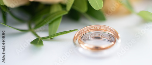 Two wedding rings in yellow and white gold, engraved with the Latin words 