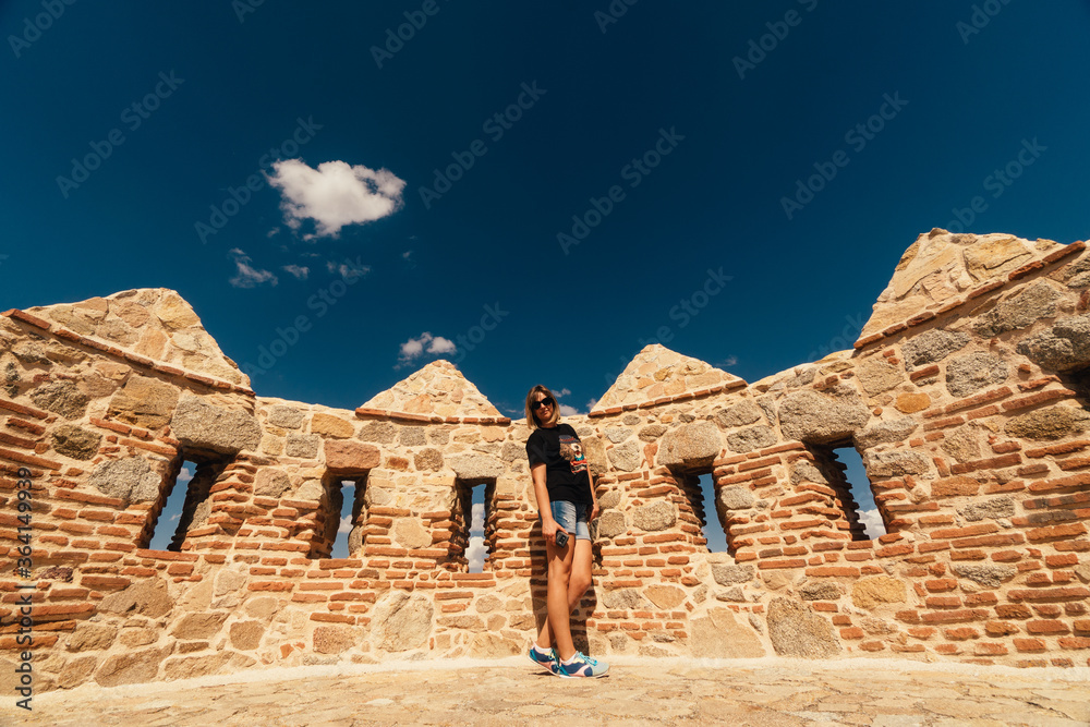 Woman tourist walks on the fortress of the city of Avila in Spain