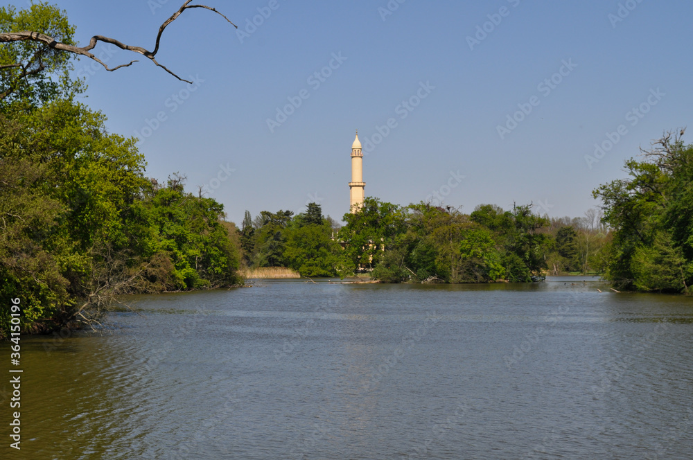 Park with a lake with a minaret in the background (Lednice Castle, Czech Republic)