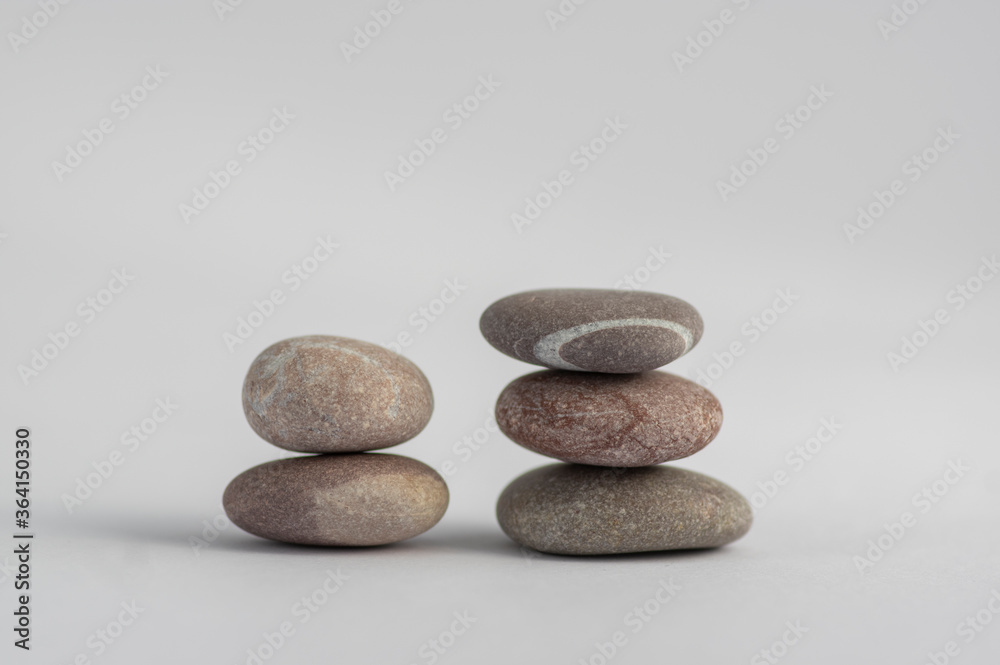 Two simplicity stones cairns isolated on white background, group of light five gray white pebbles built in two towers Two simplicity stones cairns isolated on white background, group of light five gray white pebbles built in two towers