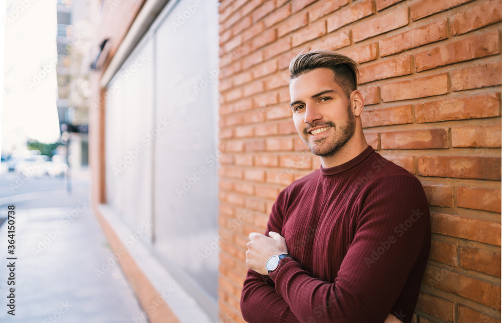 Young man against brick wall. Young man against brick wall.