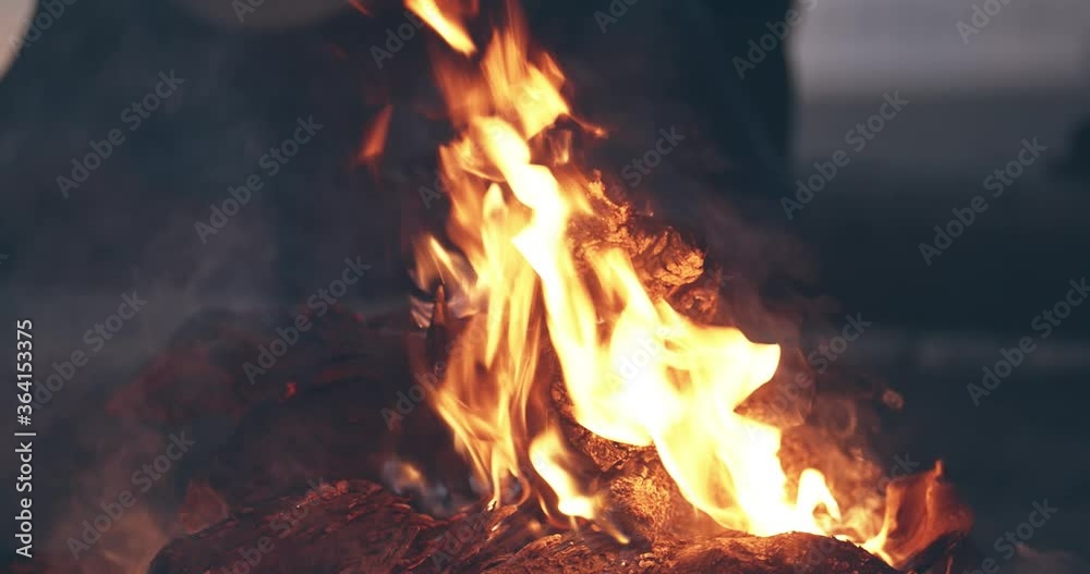 Bonfire burning trees at night. Bonfire burning brightly, heat, light, camping, big bonfire, close up bonfire flames of camping fire, burning firewood , orange fire flame and smoke Bonfire burning trees at night. Bonfire burning brightly, heat, light, camping, big bonfire, close up bonfire flames of camping fire, burning firewood , orange fire flame and smoke