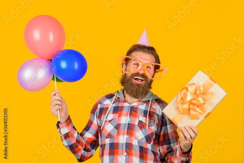 Celebrating concept. Party time. Happy birthday. Holidays and celebration, party. Happy man with present box and balloons.