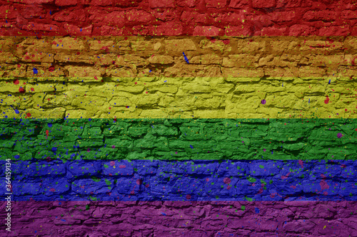 painted big gay rainbow flag on a massive old brick wall