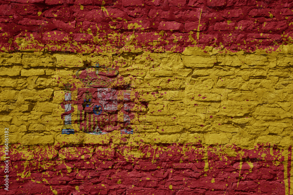 painted big national flag of spain on a massive old brick wall