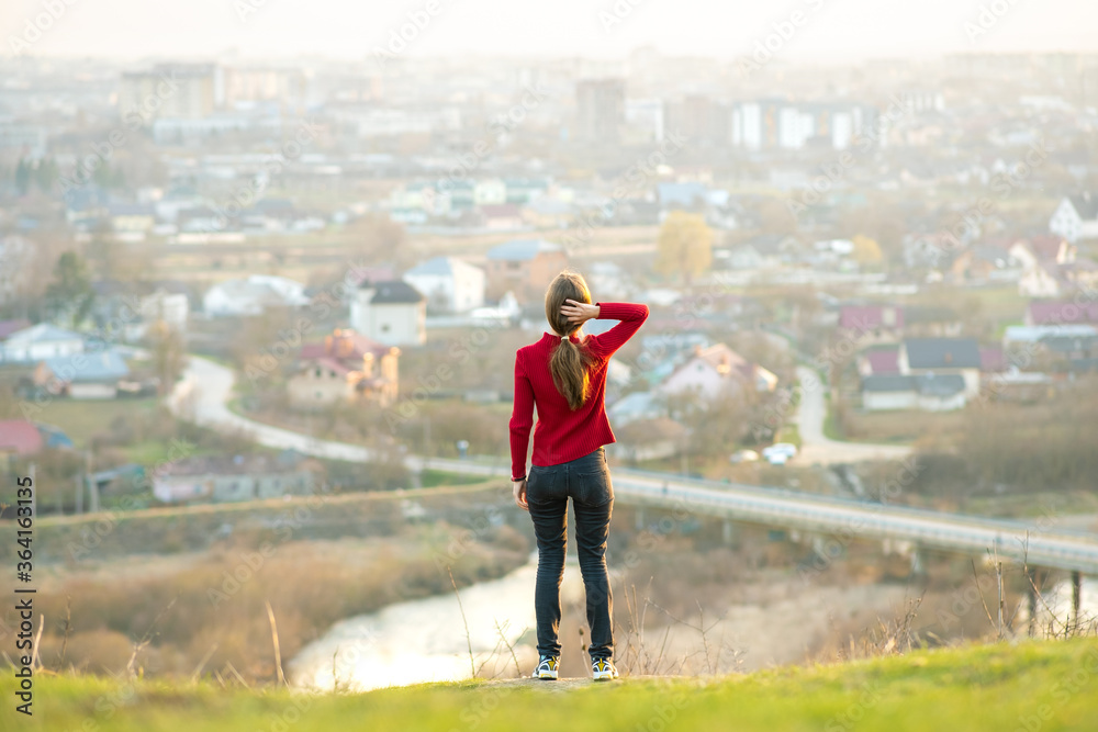 Young woman standing outdoors enjoying city view. Relaxing, freedom and wellness concept. Young woman standing outdoors enjoying city view. Relaxing, freedom and wellness concept.