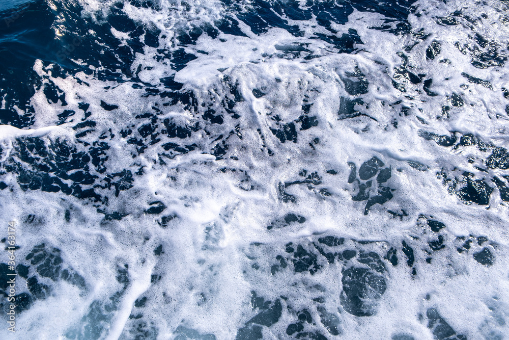 Top down aerial view of sea water surface. White foam waves texture as natural background. Top down aerial view of sea water surface. White foam waves texture as natural background.