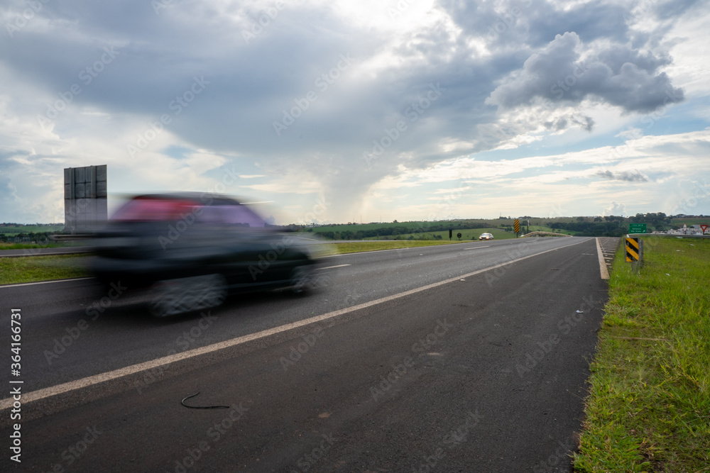 Fototapeta premium Carro em movimento na estrada rodovia Brasil a céu aberto. 