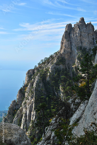 Beautiful mountain scenery on a sunny day. Mountain peaks against a background of blue sky and sea.