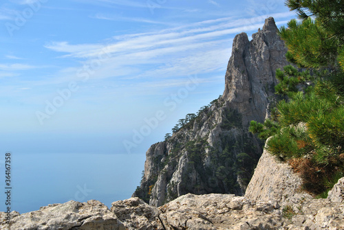 Beautiful mountain scenery on a sunny day. Mountain peaks against a background of blue sky and sea.