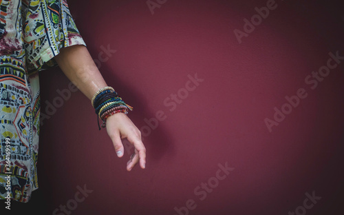 Hand with Beaded Bracelets Red Wall