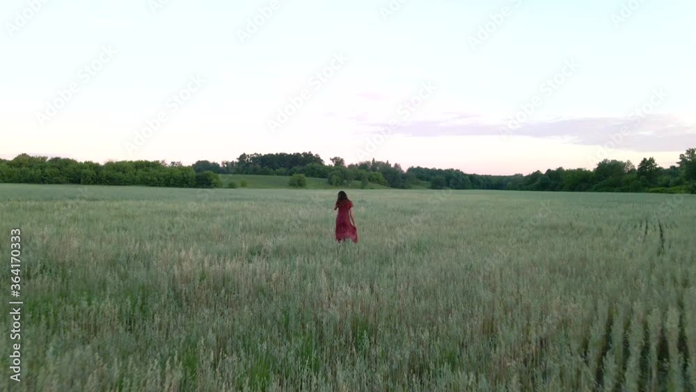Young woman with long hair in long dress runs on a field, slow motion 4k shot Young woman with long hair in long dress runs on a field, slow motion 4k shot