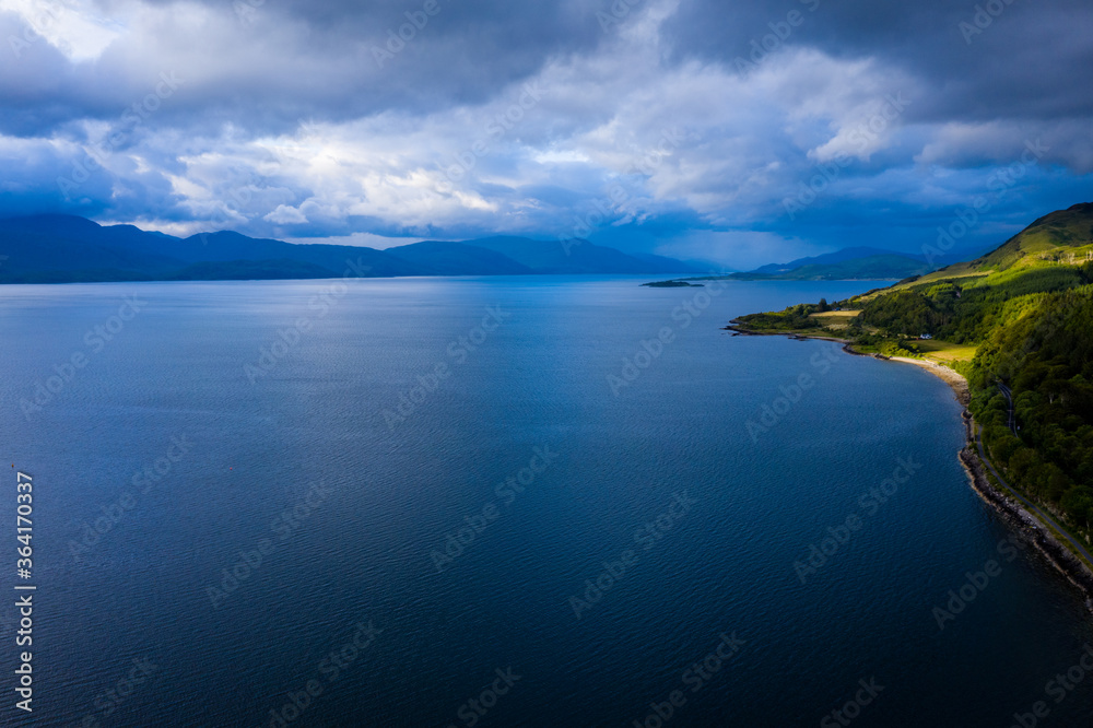 Aerial view of the sound of shuna and shuna island on the west coast of the argyll region of the highlands of Scotland during a summer storm showing a salmon fish farm