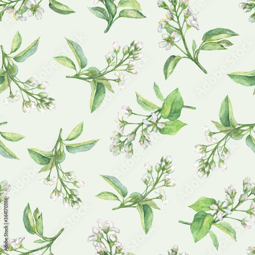 Watercolor blooming twigs on a light green background. Seamless floral pattern in delicate pastel colors.