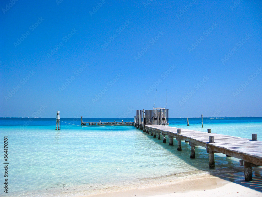 Wooden Fishing and Boating Beach Pier Extending into Beautiful Blue Ocean at a Tropical Resort