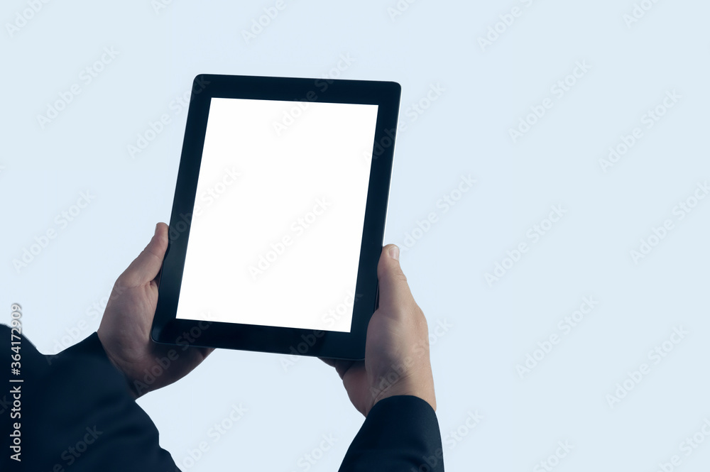 Mock up technology. Businessman in blue jacket is holding a tablet with a white screen on a light background. Mock up technology. Businessman in blue jacket is holding a tablet with a white screen on a light background.
