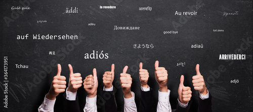 many thumbs up and blackboard with message GOODBYE in different languages photo
