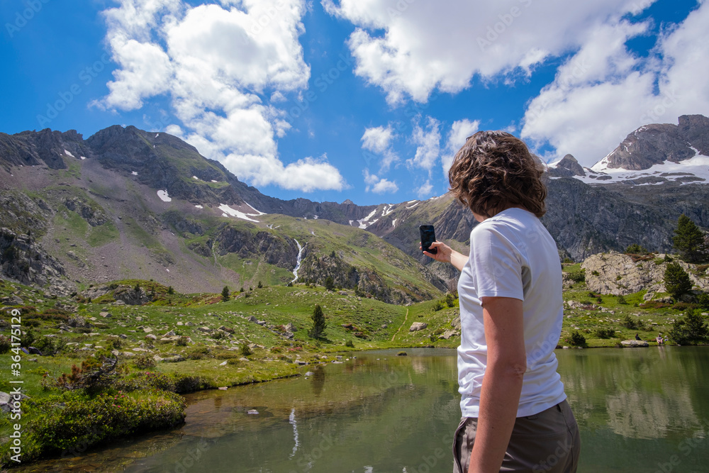 woman taking photo with a smartphone on a glacier lake