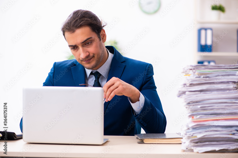 Young male employee unhappy with excessive work Young male employee unhappy with excessive work