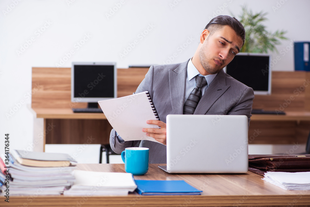 Young male employee unhappy with excessive work Young male employee unhappy with excessive work