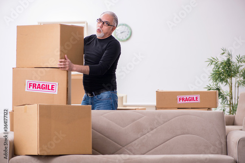 Old male professional mover doing home relocation © Elnur