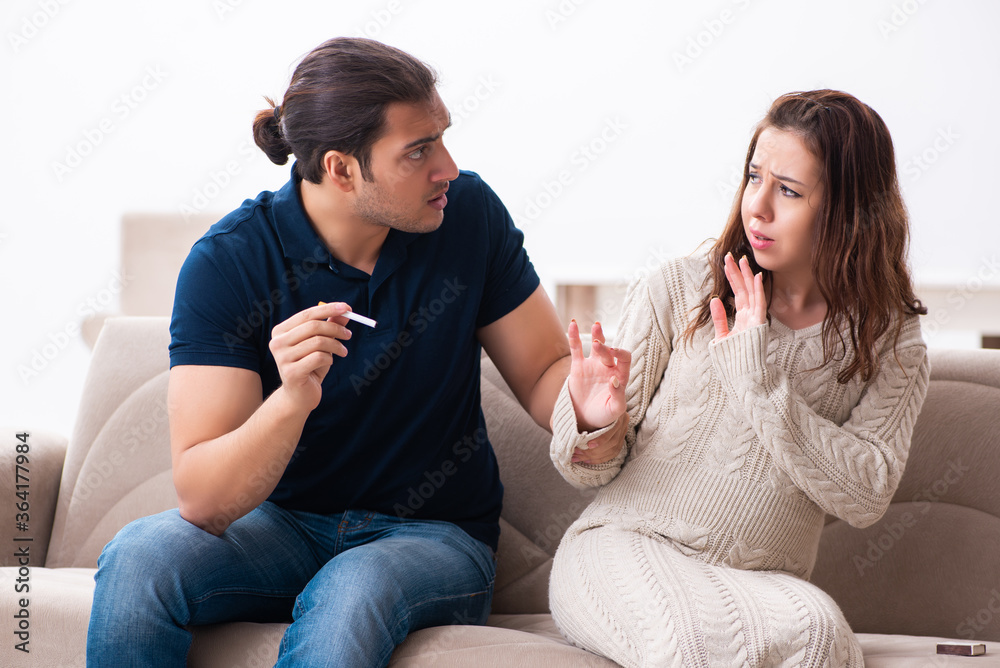 Man and pregnant woman in antismoking concept