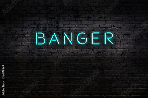Night view of neon sign on brick wall with inscription banger