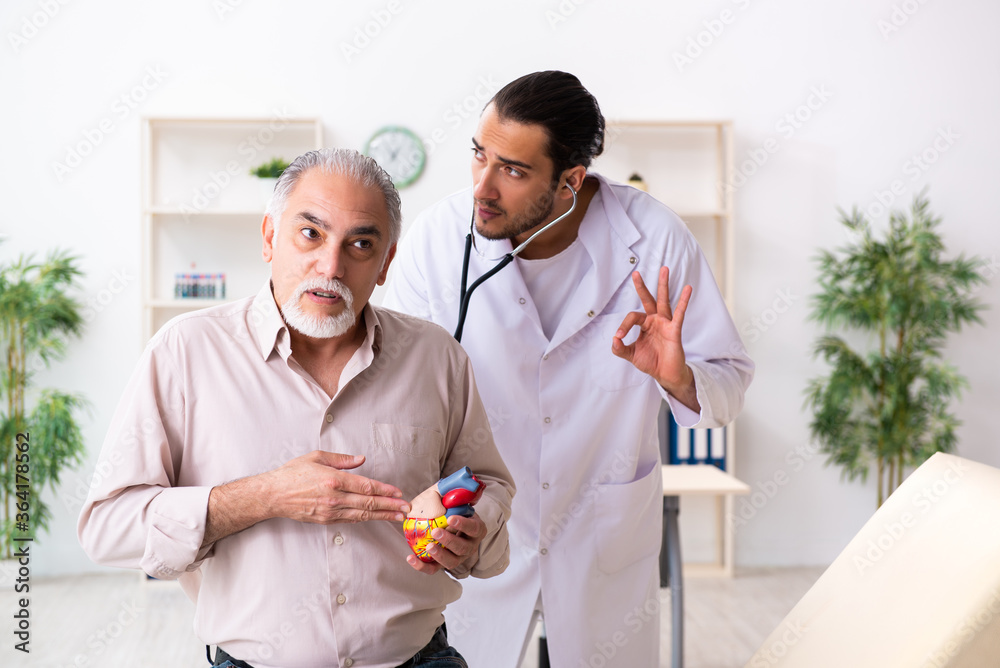 Old man visiting young male doctor cardiologist