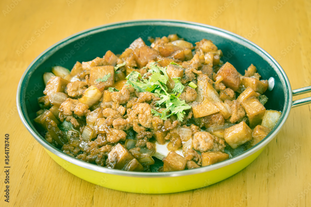 Stir Fried Pork with Onion and Garlic and Black Soy Sauce and Coriander Topping and Tofu in Pan on Wood Table with Natural Light in Vintage Tone Stir Fried Pork with Onion and Garlic and Black Soy Sauce and Coriander Topping and Tofu in Pan on Wood Table with Natural Light in Vintage Tone
