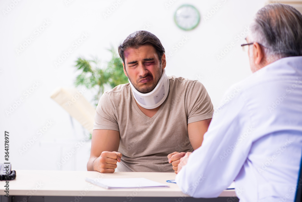 Obraz premium Young face injured man visiting experienced male doctor traumato