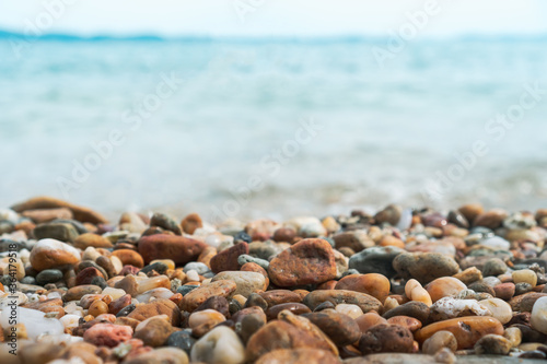 Selective focus on rocks texture with blur beach in background.