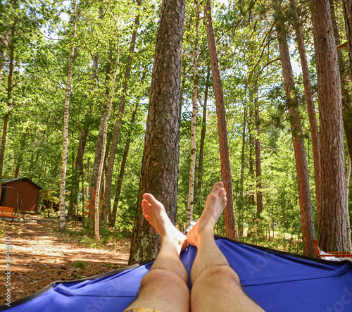 Feet relaxing in a hammock in the verdant forest