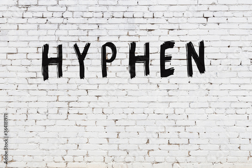 White wall with black paint inscription hyphen on it