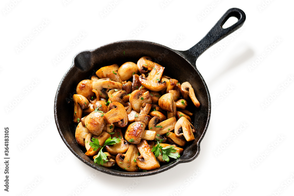 Fried mushrooms with fresh herbs in black cast iron pan isolated on white background. Fried mushrooms with fresh herbs in black cast iron pan isolated on white background.