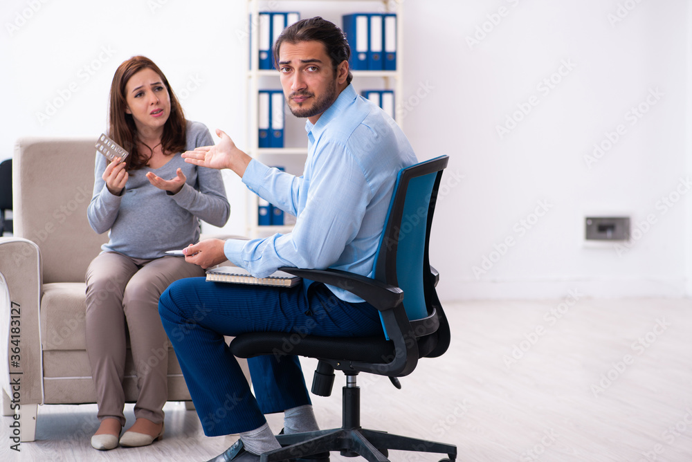 Pregnant woman visiting young male psychologist Pregnant woman visiting young male psychologist