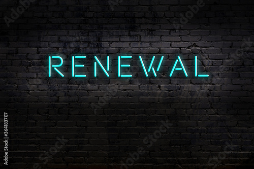 Night view of neon sign on brick wall with inscription renewal photo