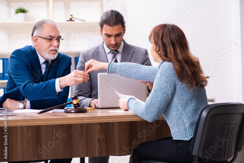 Young woman in courthouse with judge and lawyer