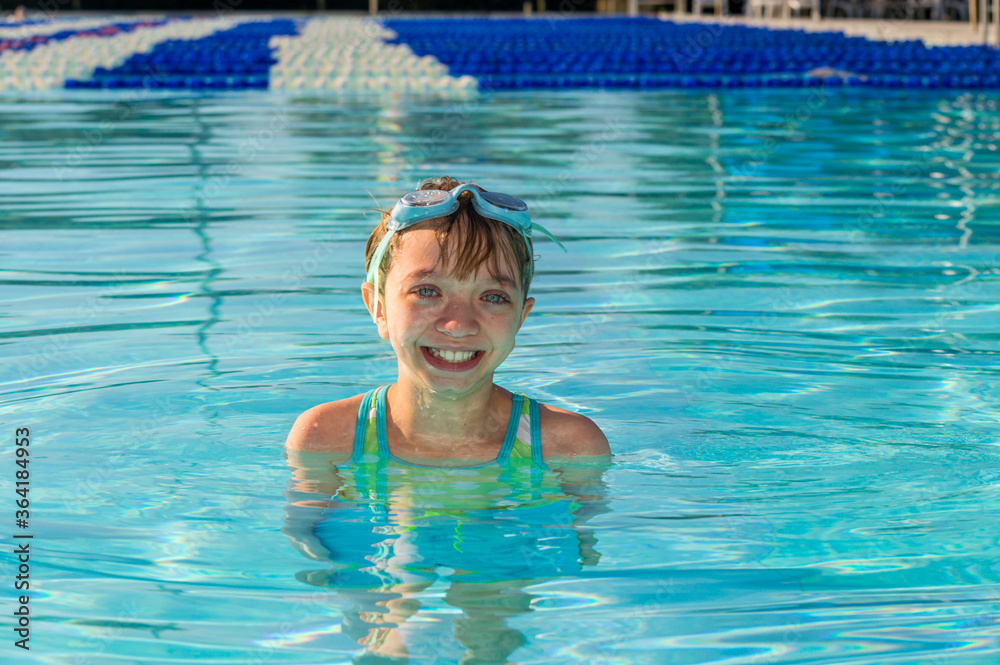 Young girl smiling while swimming in a swimming pool