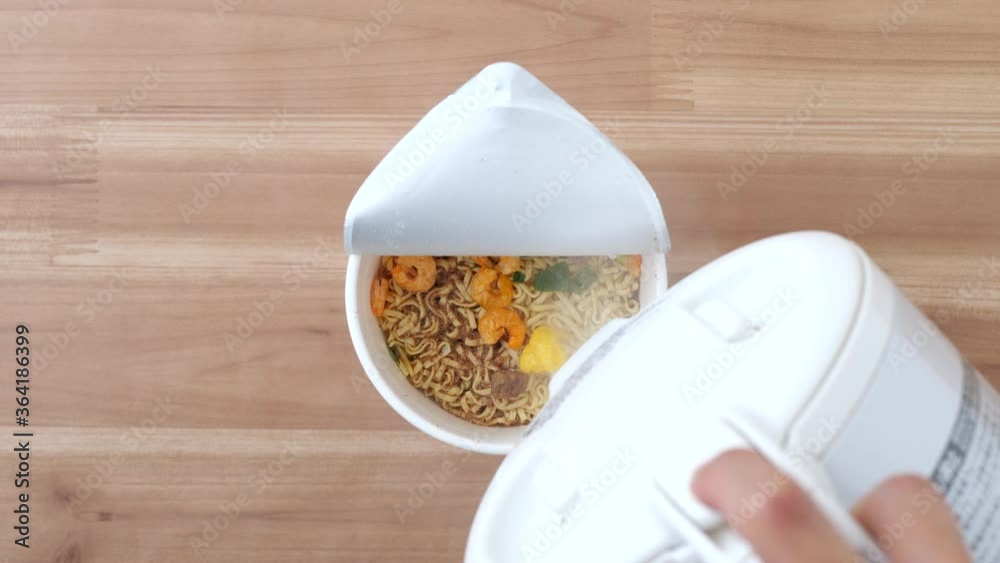 Pour boiling water from an electric kettle into cup noodles. Japanese  instant ramen. Top view. High angle. Easy cooking. Living alone. Delicious  food. Busy day Stock Video | Adobe Stock
