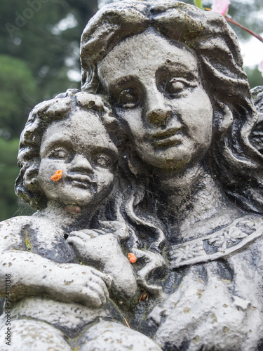 Closeup of weathered grave statue of the Madonna and baby  Jesus