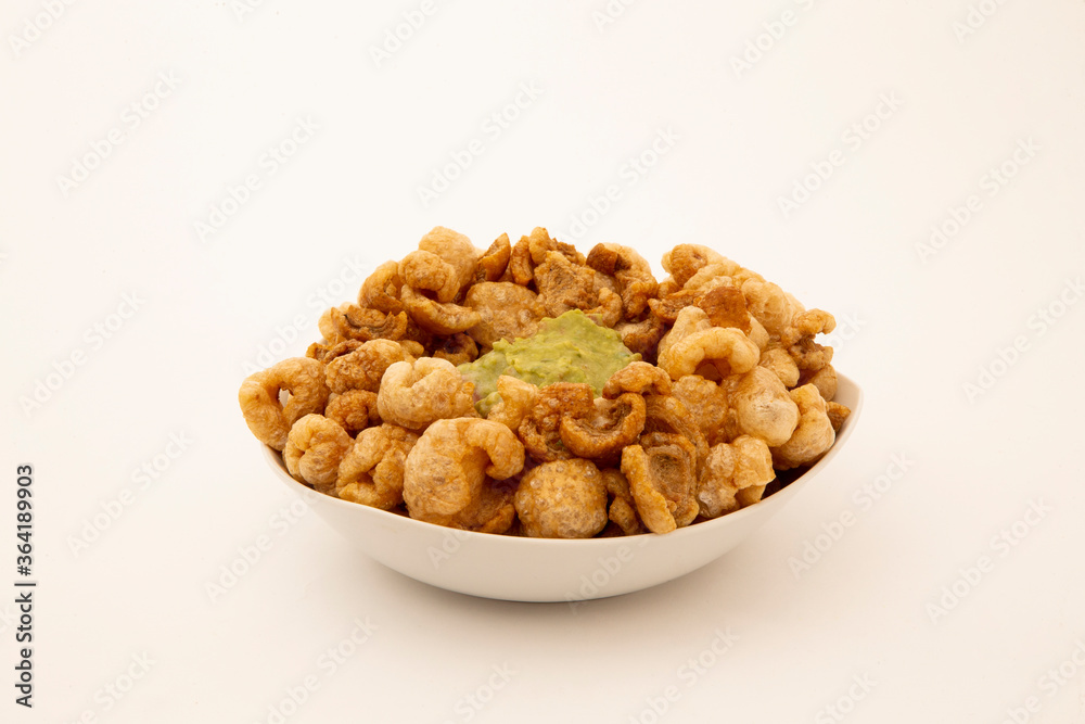 pork rind in bowl and with guacamole in white background pork rind in bowl and with guacamole in white background