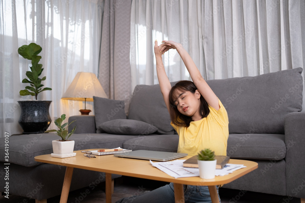 Young asian woman tried closing laptop relax from hard work at home.