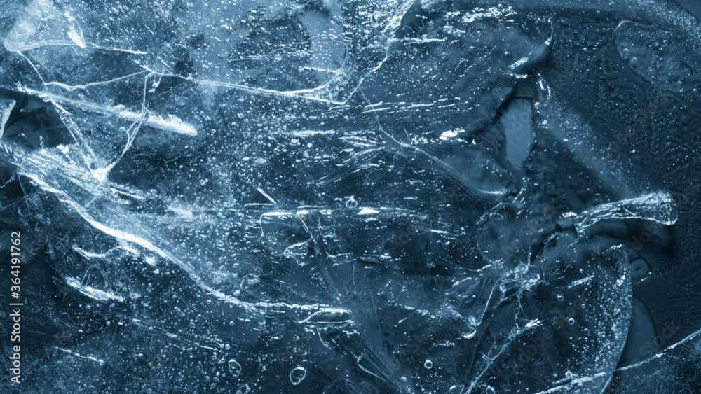 Close-up of melting ice texture. Studio shot close-up of the blue surface of cracked melting ice in time lapse.